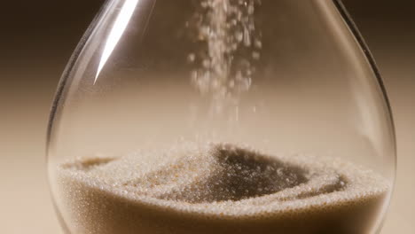 close-up of sand flowing in an hourglass