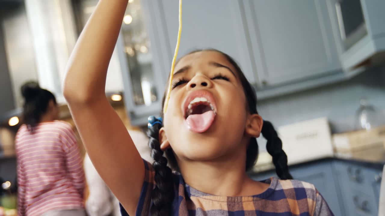 Ragazza che mangia spaghetti in cucina 4K