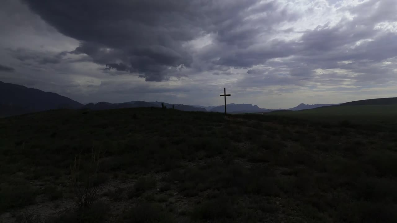 Christian cross on top of a hill with a cloudy and slightly dark sky but at the same time with light showing a feeling of what Christian doctrine is 4k 60 fps