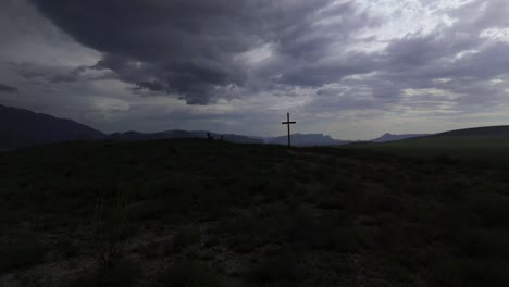 christian cross on top of a hill with a cloudy and slightly dark sky but at the same time with light showing a feeling of what christian doctrine is 4k 60 fps