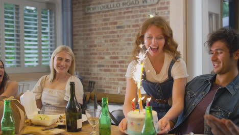 grupo multicultural de amigos celebrando cumpleaños con fiesta y pastel en casa juntos