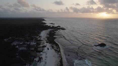 Aerial-view-above-mexican-coastline-during-sunset-in-Tulum,-Mexico
