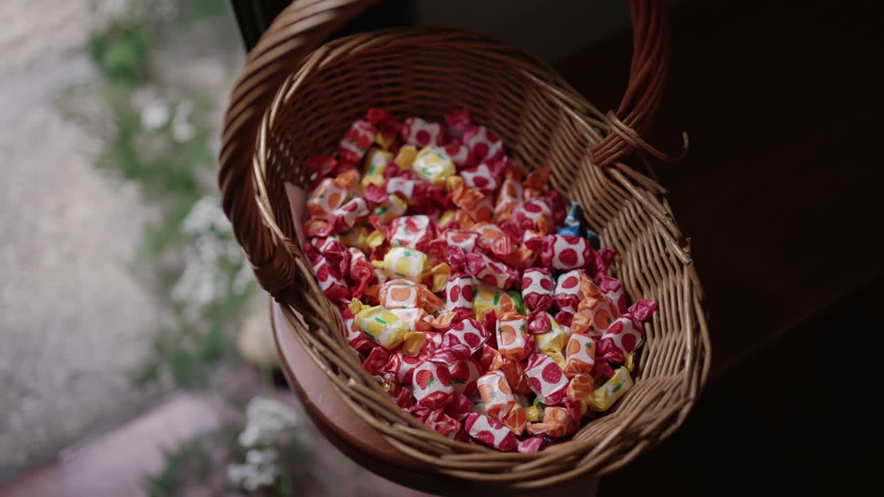 woven basket filled with colorful fruit candies wrapped in paper with fruit designs