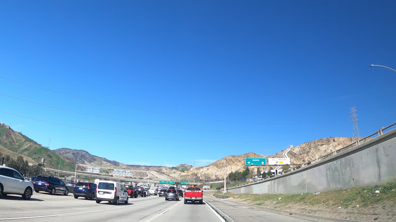 Transport Vehicles Driving Fast On The Asphalt Road In Los Angeles, California Under The Blue Sky With Traffic Jam On Some Lanes - Timelapse
