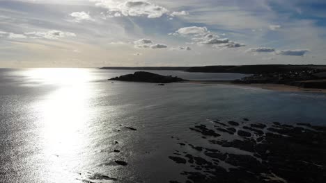 Aerial-View-Over-Sunlight-English-Channel-With-Silhouette-Coastline-At-Bantham-Beach