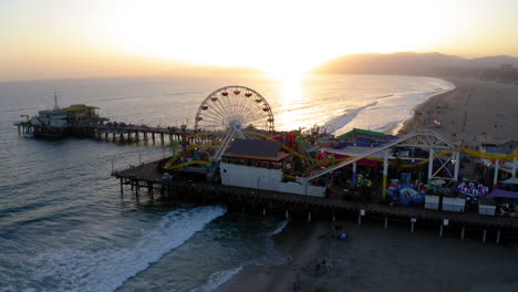 santa monica pier at sunset with ferris wheel and beach