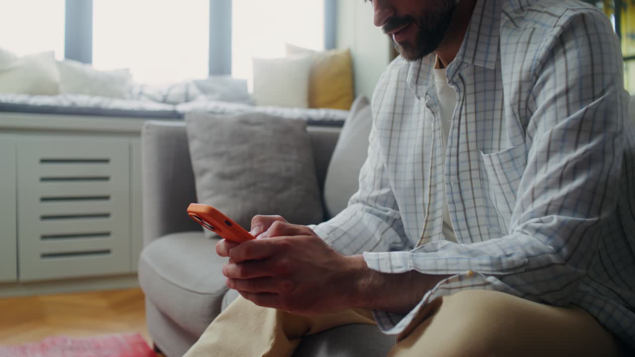Man using smartphone on a couch