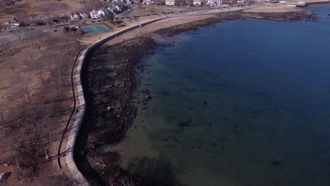 Flying-over-the-bike-and-walking-path-at-Western-Harbor-in-Gloucester,-Massachusetts