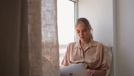 Focused-freelancer-woman-works-on-project-via-laptop-at-home