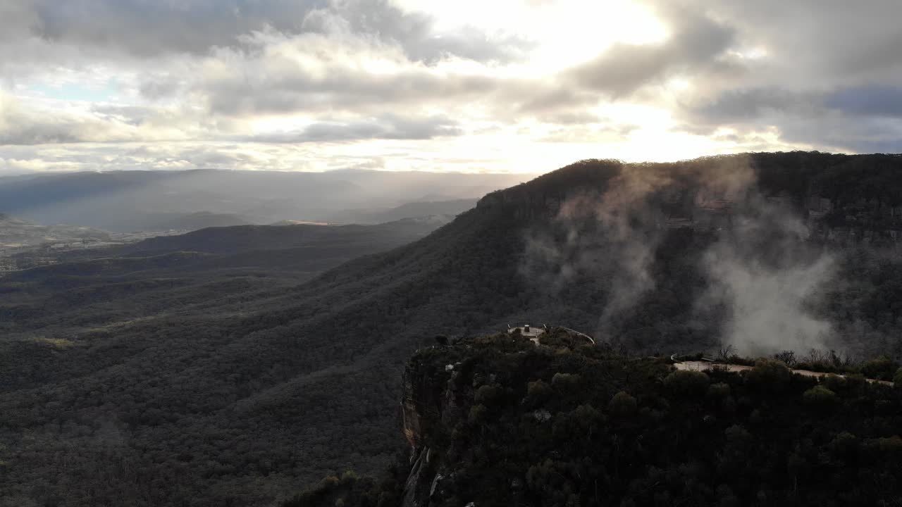 Sunset over Blue Mountains region looking towards a valley with misty clouds and a tourist pathway