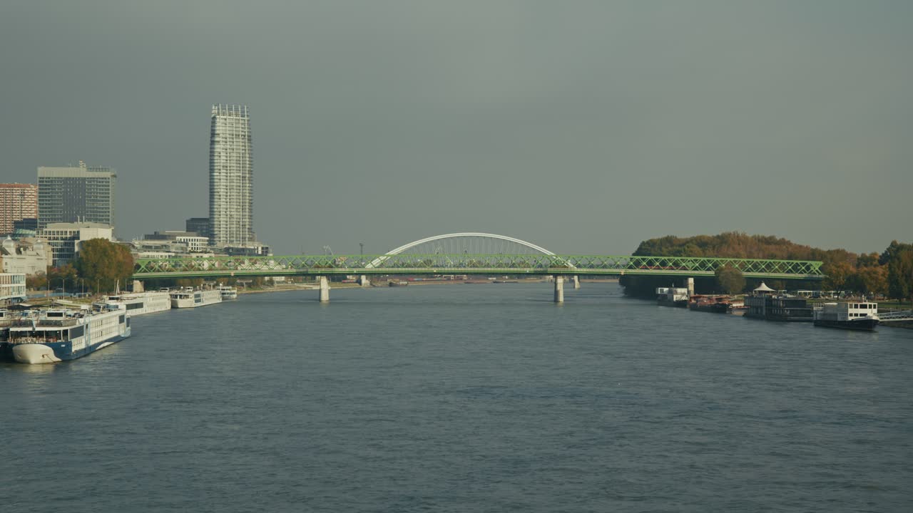 Bratislava Danube River with boats, modern skyline, and green steel bridges in view