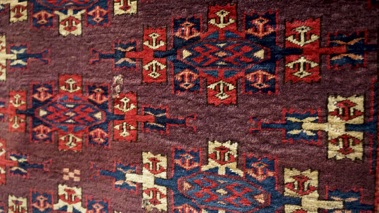 Close up detail of antique Turkmen wool carpet with traditional designs