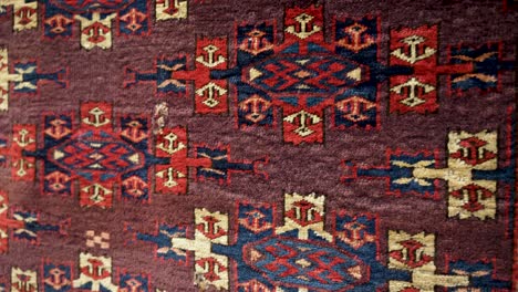close up detail of antique turkmen wool carpet with traditional designs
