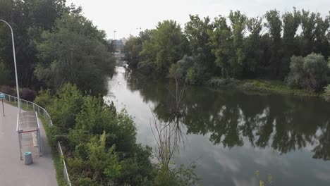 Aerial-footage-of-a-small-lake-in-Warsaw-Poland-with-trees-around-and-sky-above-it