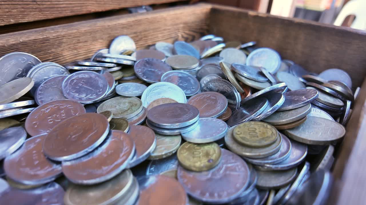 A collection of coins in a wooden box