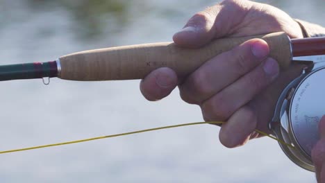 primer plano de un pescador con mosca con excelente técnica trabajando su caña y carrete