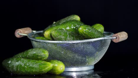 los pepinos frescos y crujientes en un colander giran lentamente.