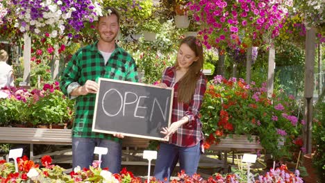 Dos-Floristas-Con-Cartel-Abierto-En-Su-Tienda