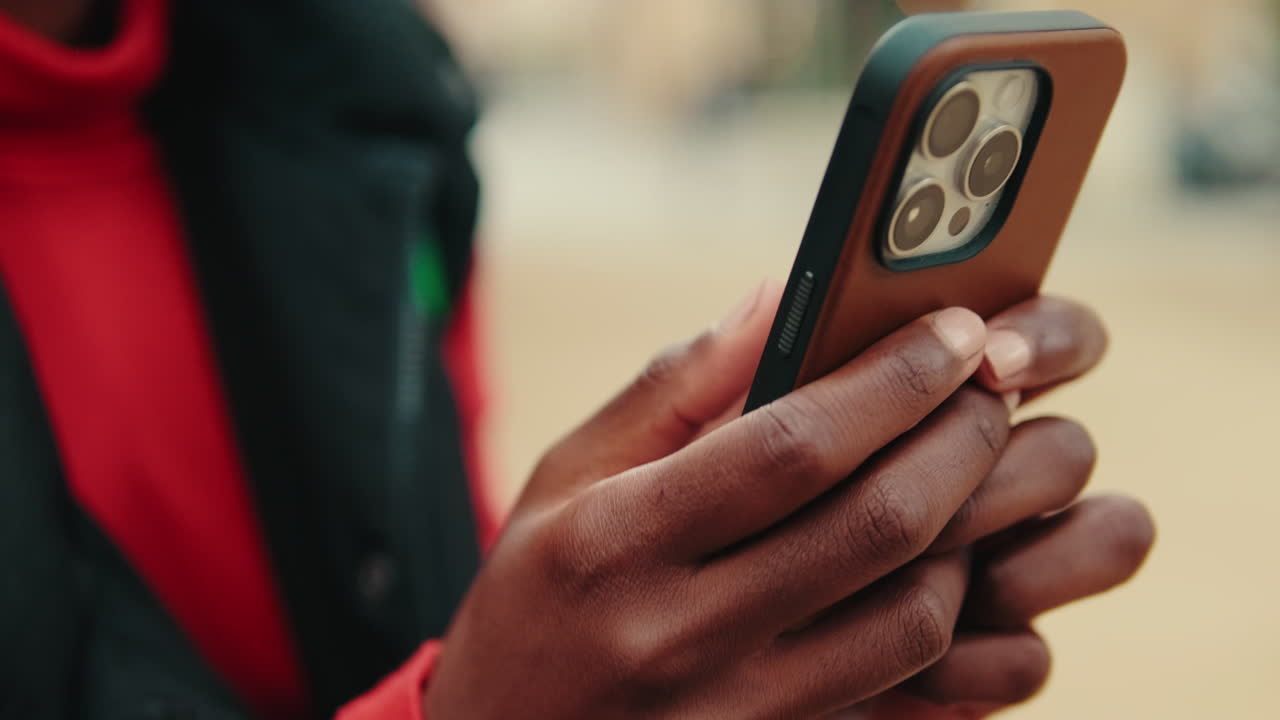 Nærbilde av en persons hender som bruker en smarttelefon