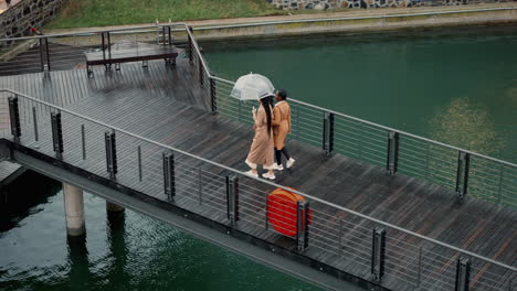 walking, above and women in the rain on a bridge