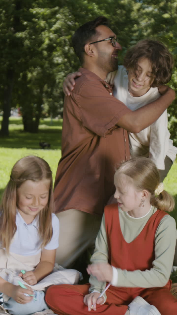 Family and friends drawing and interacting happily outdoors in a park