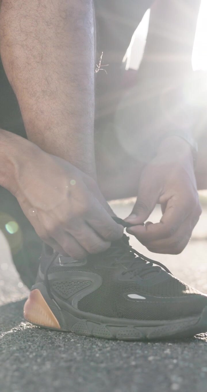 Atleta che si allaccia i lacci delle scarpe da corsa all'aperto