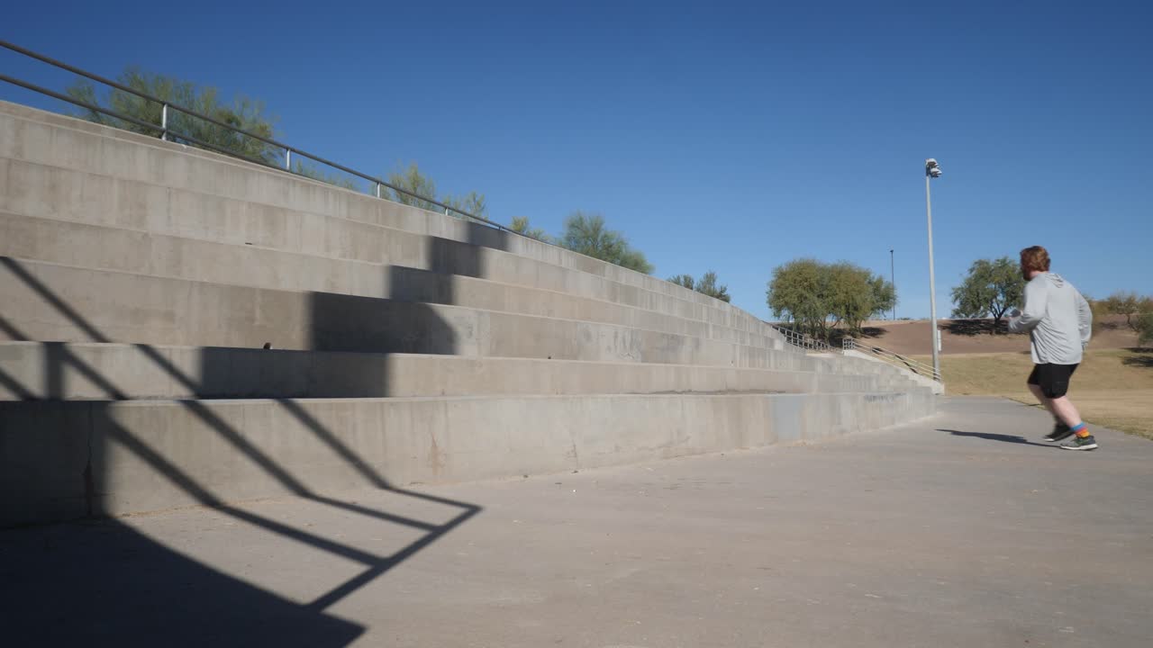 un hombre gordo y pelirrojo corre por bloques de cemento.