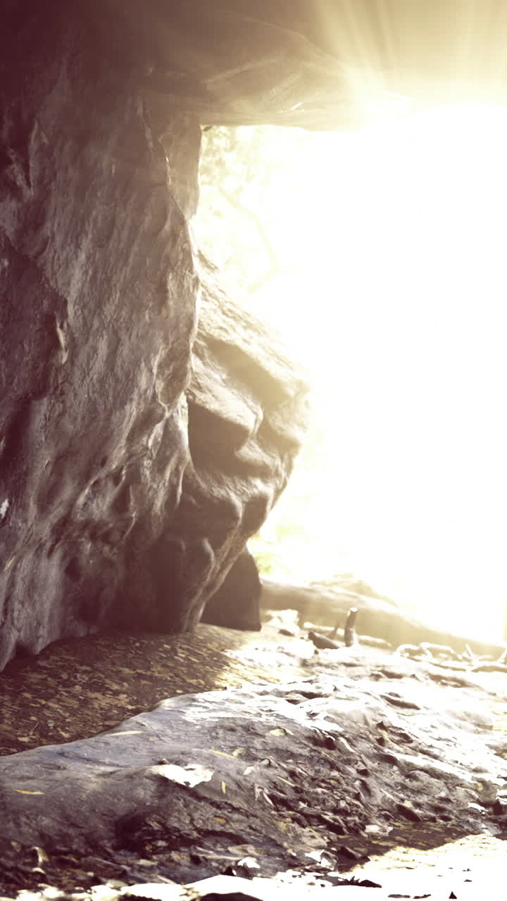 Luce solare che filtra attraverso l'apertura di una grotta in un paesaggio naturale
