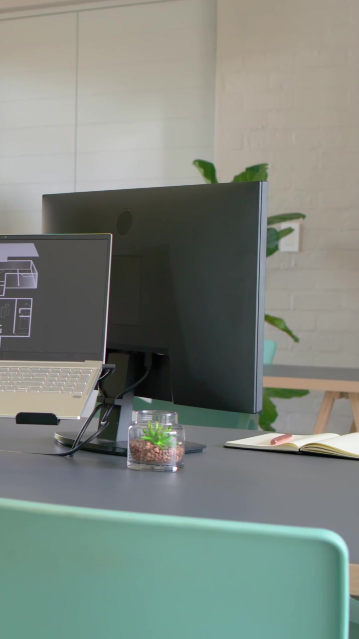 Vertical video: Shifting camera capturing setup in center at desk showing laptop monitor terrarium