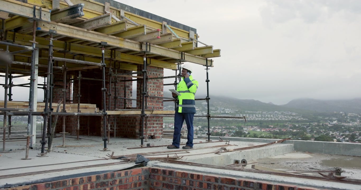Construction Manager Inspecting Building Site with Tablet