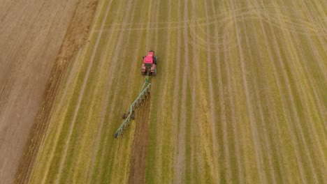 tractor moves through field with plow in transport position