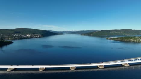 Drone-starts-with-a-scenic-view-of-Osterfjord,-moving-backwards-to-reveal-the-floating-Nordhordland-Bridge