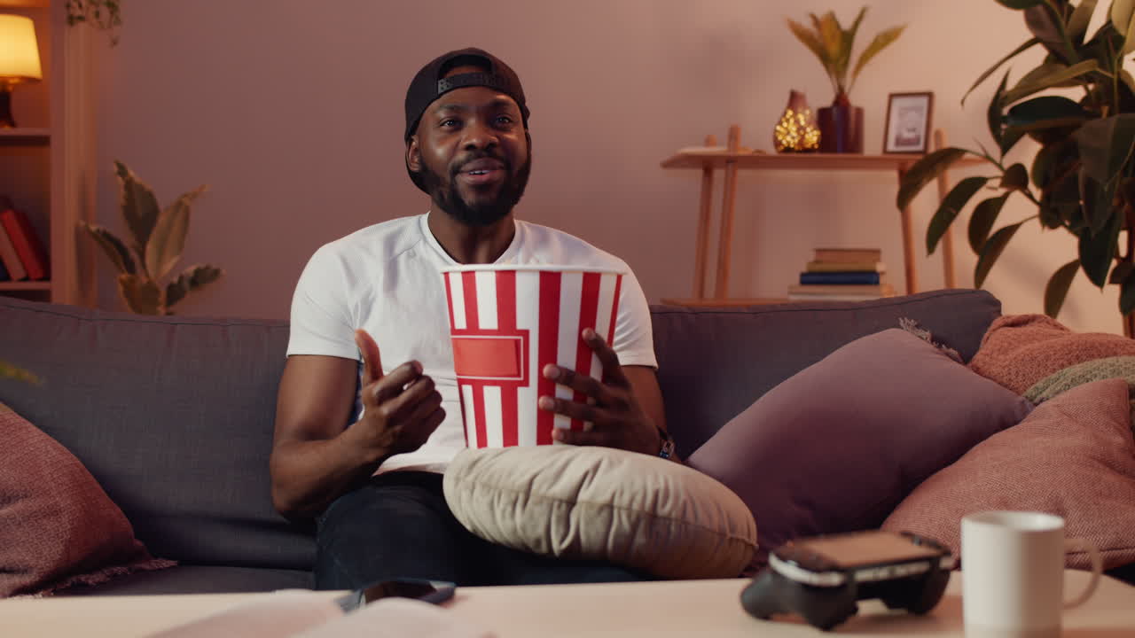 Man Watching TV with Popcorn on Couch