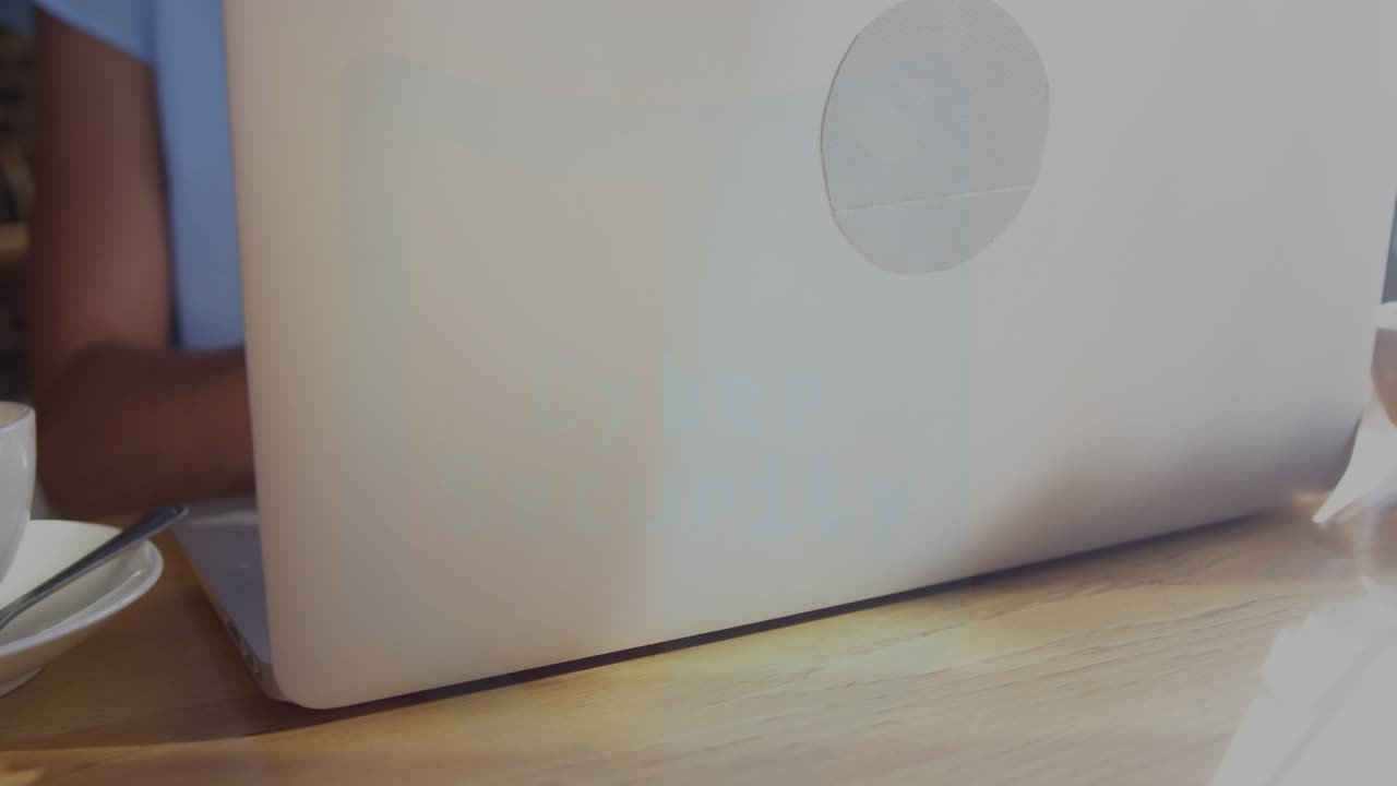 Woman typing on laptop in cafe, HUD animating from Cyber Security text scanning for threats