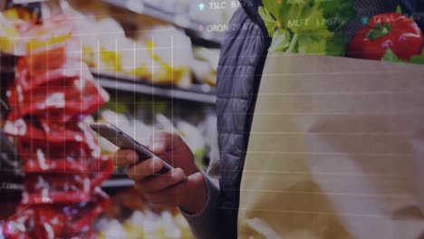 animation of graphs, trading board over midsection of caucasian man using cellphone in supermarket