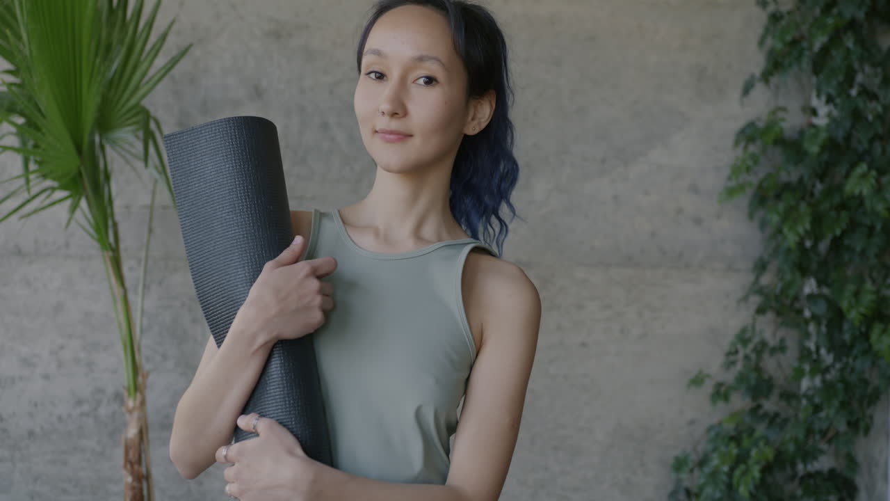 Woman holding yoga mat