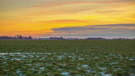 frozen fields against fiery sky during sunset in winter