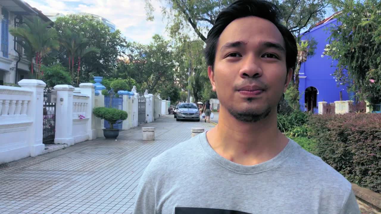 Close up Shot of a Young Millennial Man walking through a Paved Sidewalk at Daytime. Slow Motion