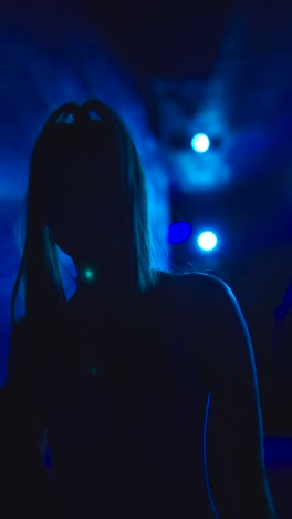 silhouette of a person dancing in blue club lights