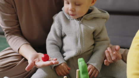 baby boy playing with mom and brother