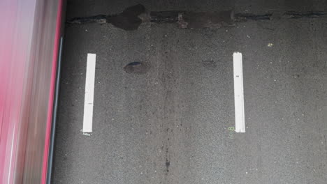 close-up straight down timelapse showing a single lane with worn white lines on aged asphalt