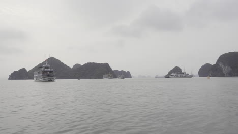 shot of halong bay with many tourist boats floating around in vietnam on a cloudy day log