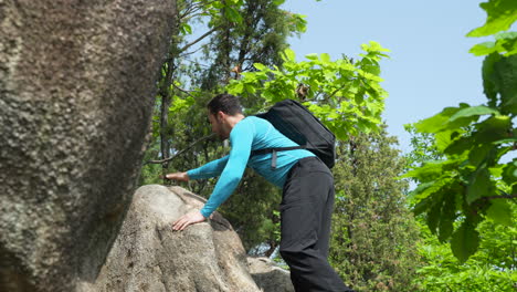 Mann-Kletterer-Mit-Rucksack-Kletterfelsen-Im-Bergwald