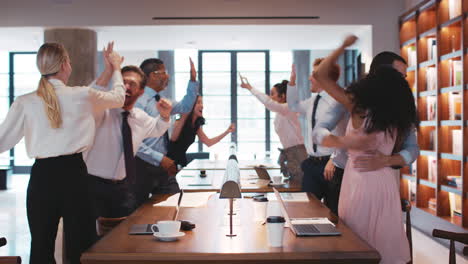 colegas de negocios celebrando un éxito en una sala de reuniones