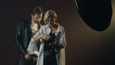 Young-male-model-and-female-photographer-showing-photos-after-photoshoot-on-the-camera-screen-while-they-are-smiling