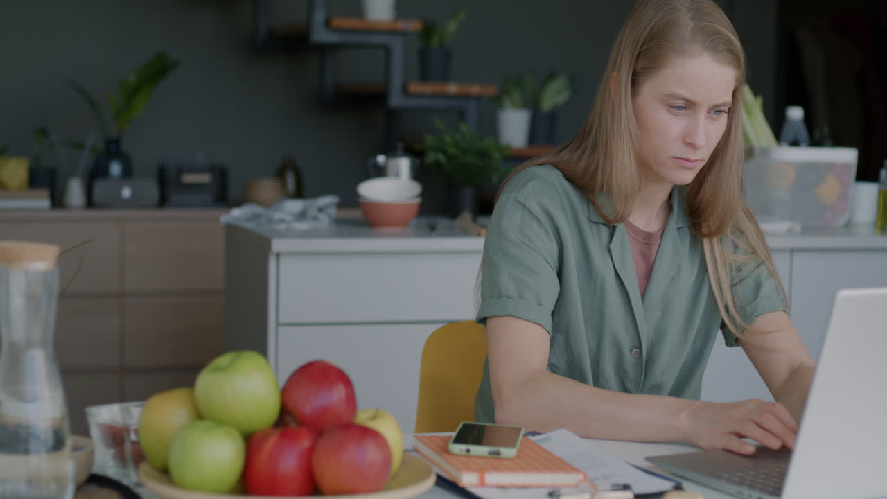 mujer trabajando desde casa en una cocina moderna