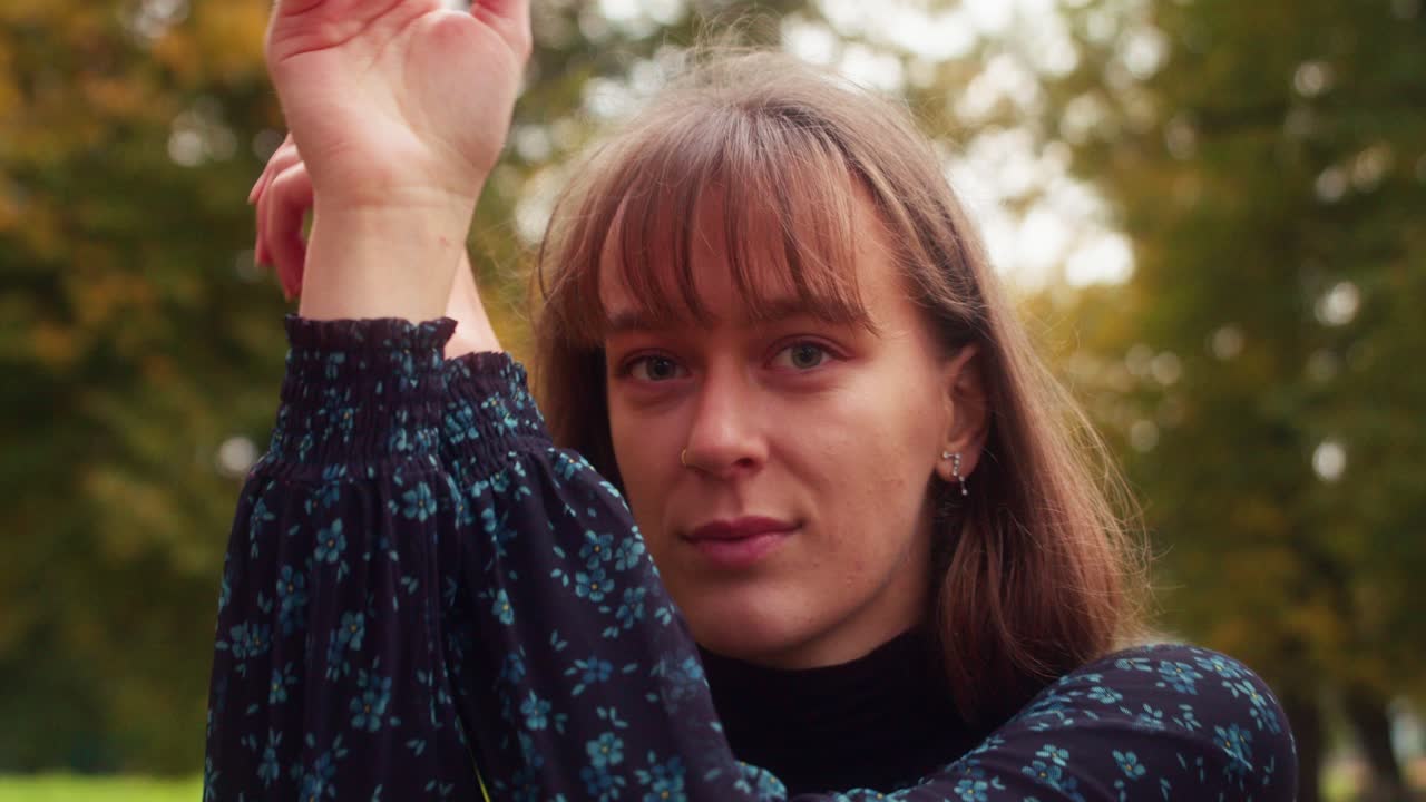 girl dancing with her hands, vogue, tectonic, electro, techno movements, in a sunny park during autumn, slow motion slomo shot.