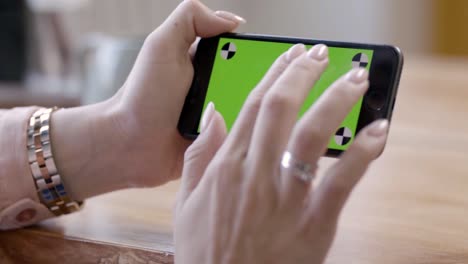 woman recording video with green screen on smartphone