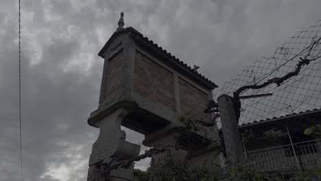 historical galician granary next to a fence on a cloudy day in lonoa, spain