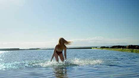 woman playing with water at beach 4k